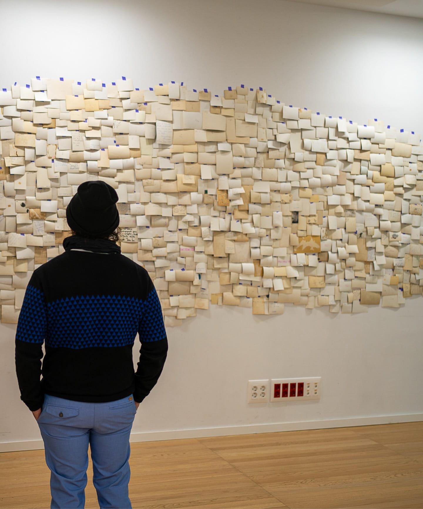 Una persona contempla una instalación mural durante NUDOS.